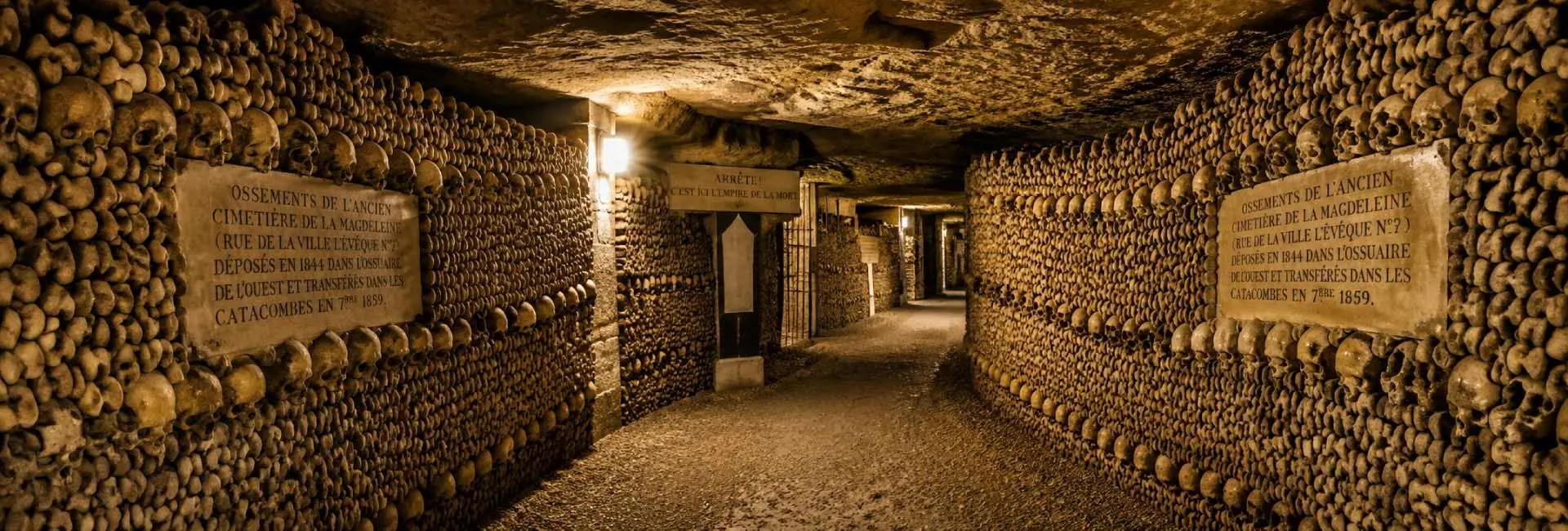 The Catacombs of Paris with walls lined with skulls and bones in an underground ossuary