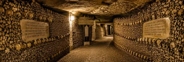 The Catacombs of Paris with walls lined with skulls and bones in an underground ossuary