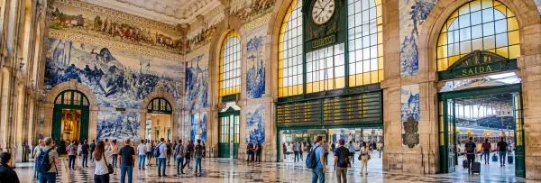 São Bento Railway Station in Porto, Portugal, featuring historic stone arches and blue-and-white azulejo tile murals.