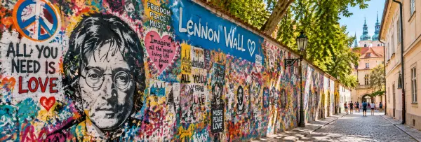 Lennon Wall in Prague covered with colorful graffiti, peace symbols, and John Lennon artwork