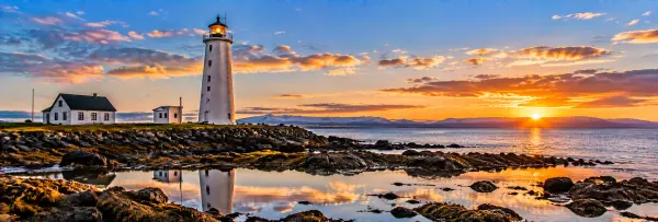 Grotta Lighthouse in Reykjavík overlooking the rocky coast, sea and distant mountains