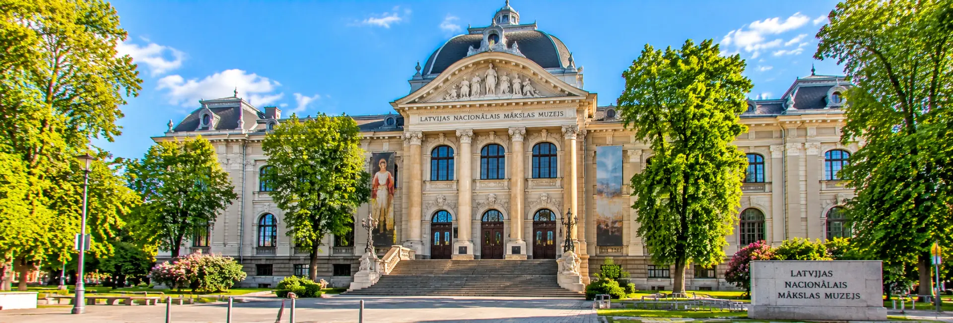 Latvian National Museum of Art in Riga, featuring grand neoclassical architecture, ornate columns and a domed roof.
