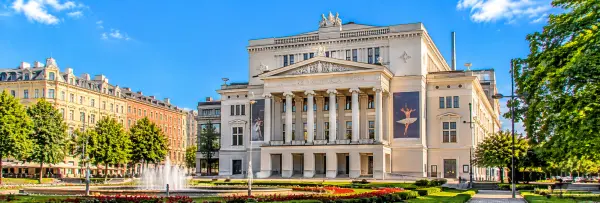 Latvian National Opera and Ballet in Riga, featuring grand neoclassical architecture, elegant columns and gardens.