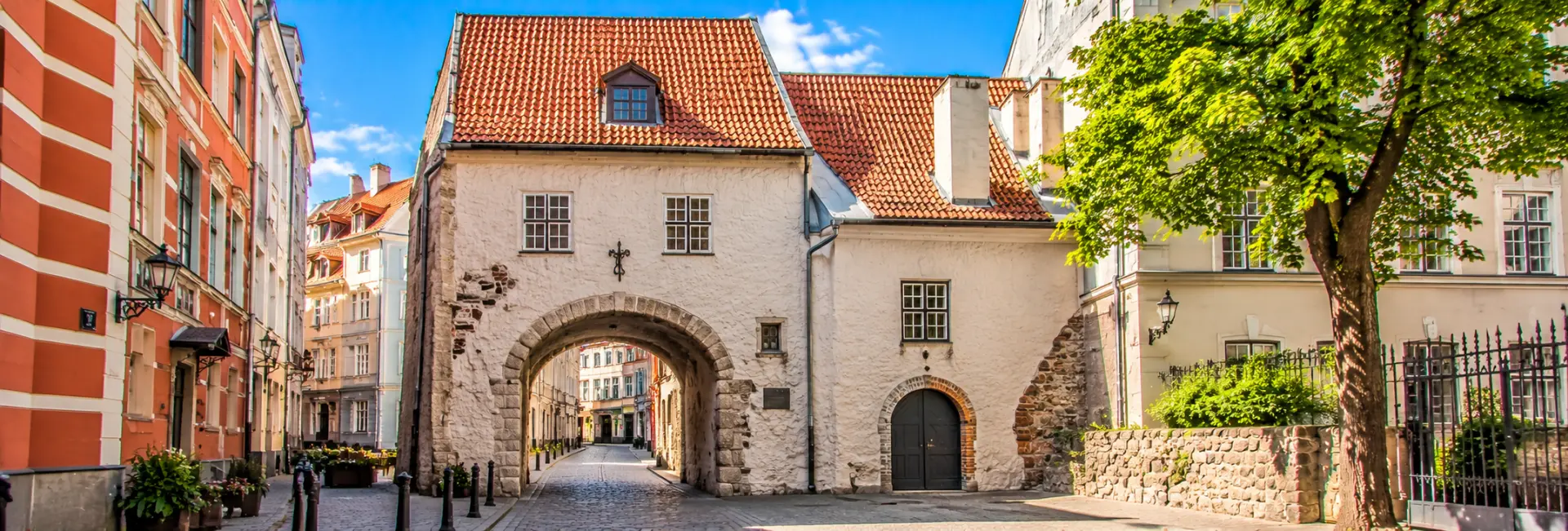 Swedish Gate in Riga, Latvia, featuring a historic stone archway, cobblestone street and medieval Old Town buildings.