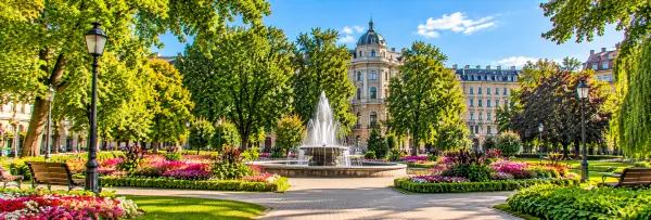 Vērmanes Garden in Riga, Latvia, featuring colorful flowerbeds, a decorative fountain, walking paths and lush greenery.