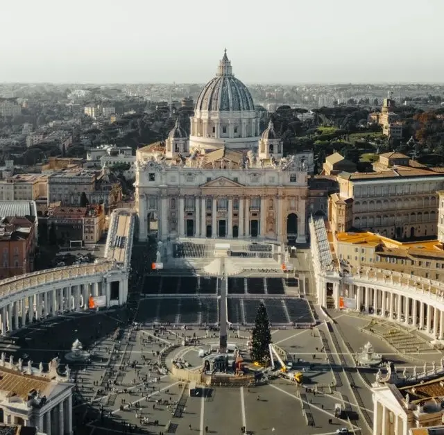 Aerial view of St. Peter's Basilica and St. Peter's Square in Vatican City during daylight.