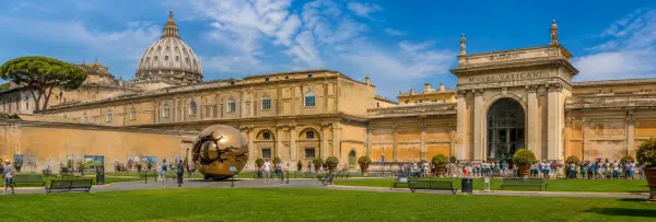 Panoramic view of the Vatican Museums entrance and St. Peter's Basilica dome in Vatican City.