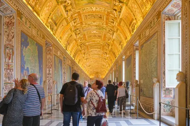 Visitors exploring the Gallery of Maps inside the Vatican Museums in Vatican City.