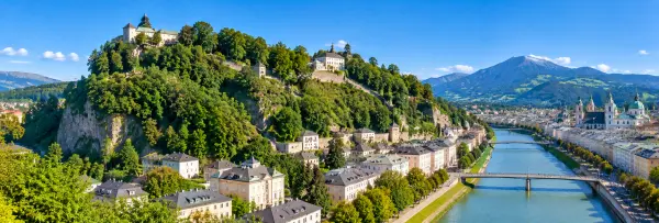 Panoramic view of Mönchsberg and Salzburg, Austria, with the Salzach River and historic cityscape.