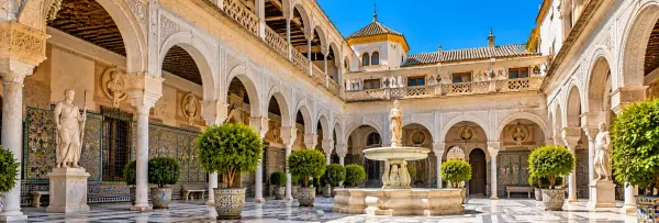 Casa de Pilatos in Seville, Spain, featuring an ornate courtyard with Moorish arches and colorful tiles.