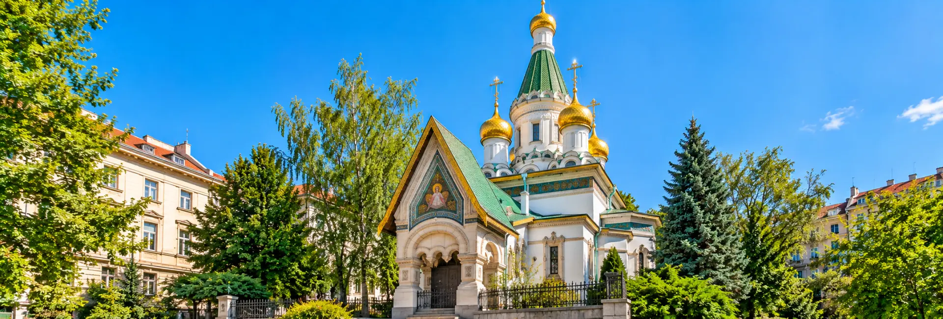 Russian Church of St. Nicholas in Sofia, Bulgaria, featuring golden onion domes, green roofs, and ornate architecture.