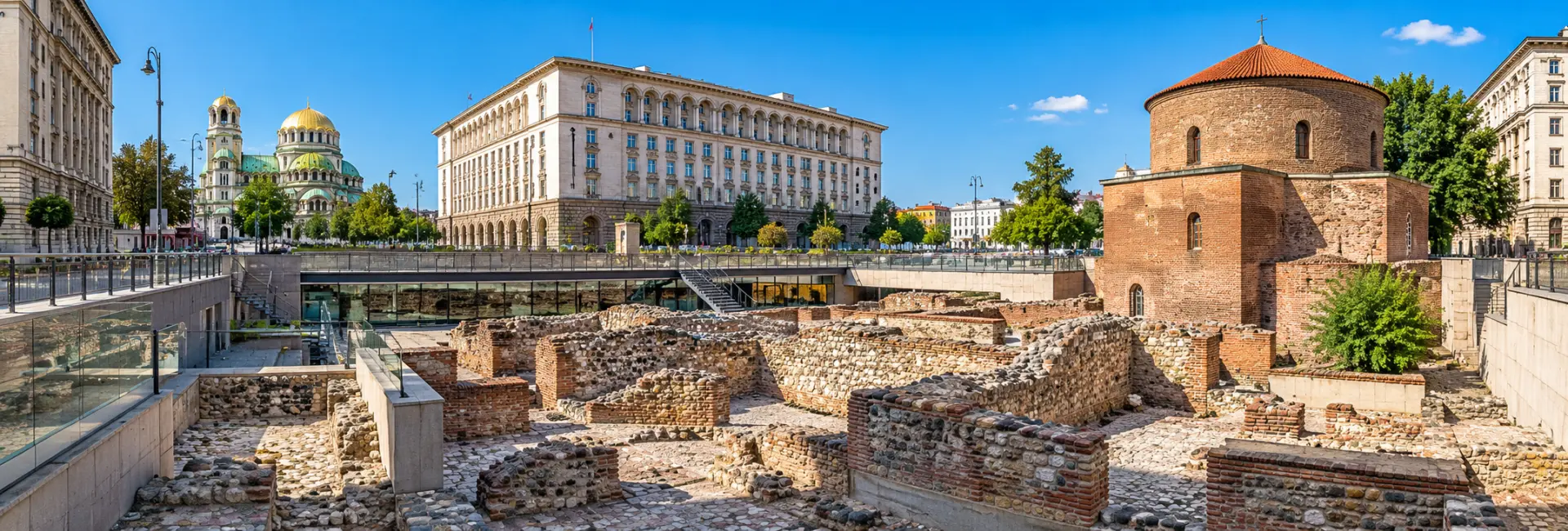 Ancient Roman ruins at Serdica Archaeological Complex in Sofia, Bulgaria, surrounded by historic city buildings.