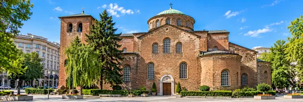 St. Sofia Church in Sofia, Bulgaria, featuring historic red-brick architecture, arched windows and a peaceful setting.