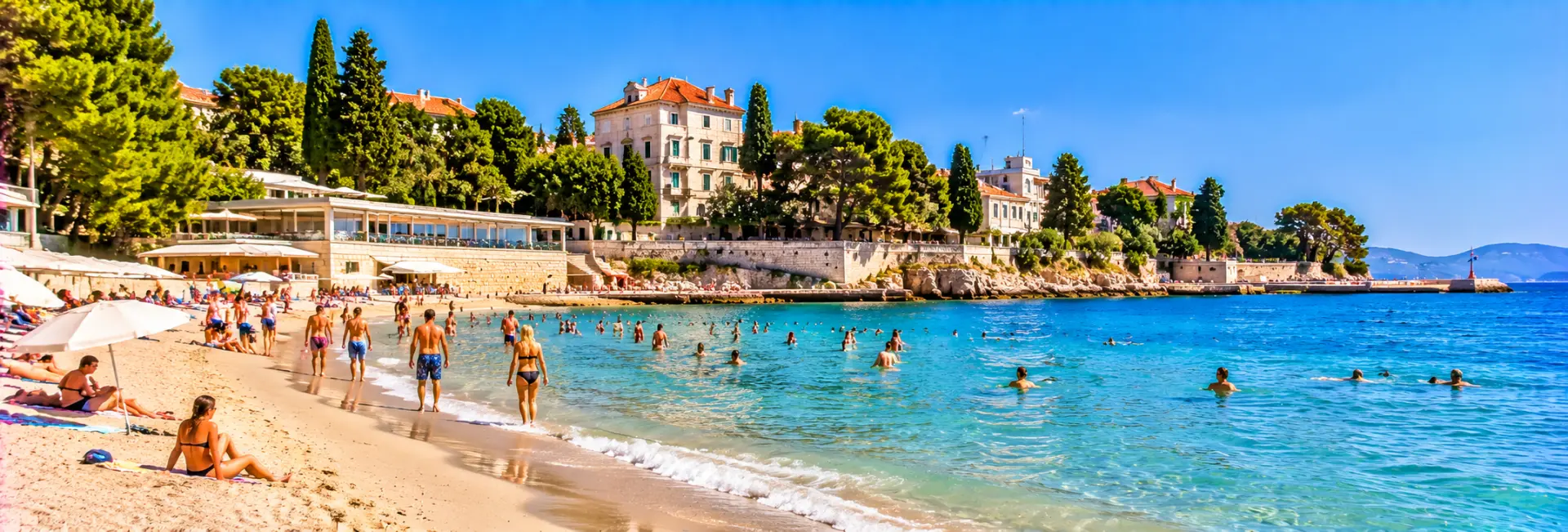 Bačvice Beach in Split, Croatia, with sandy shores, clear Adriatic waters and swimmers.