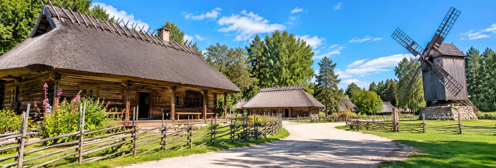 Estonian Open Air Museum in Tallinn featuring traditional wooden farmhouses, thatched roofs and a historic windmill.