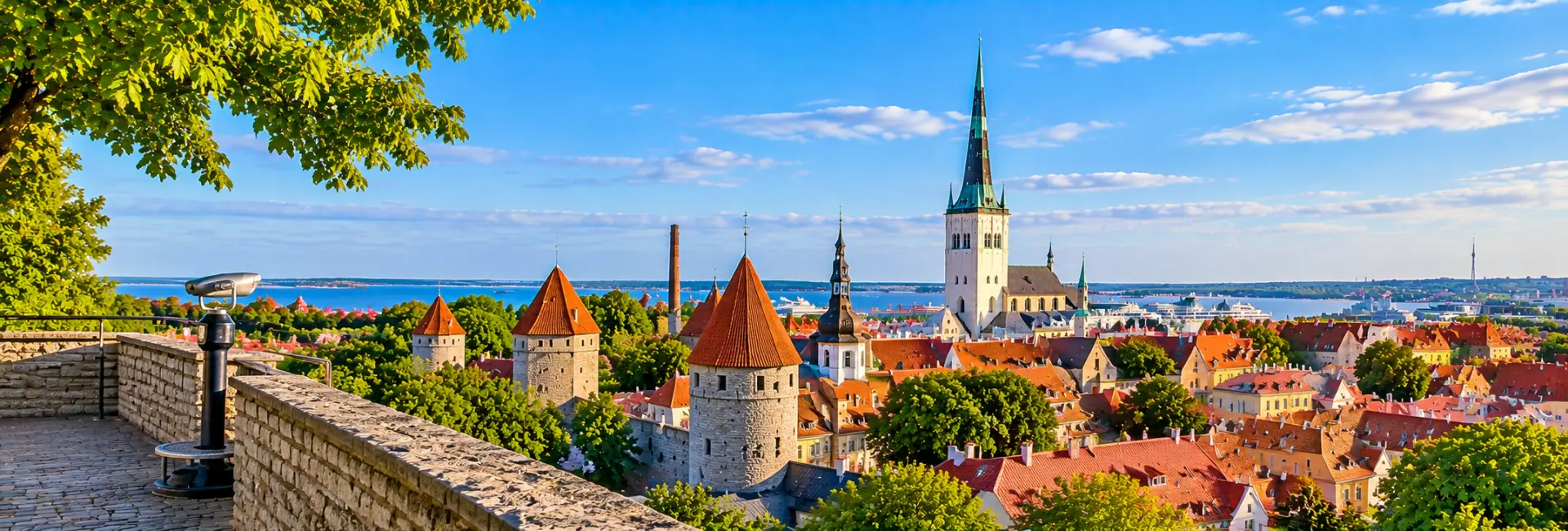 View from Patkuli Viewing Platform in Tallinn, featuring medieval towers, red rooftops and the Baltic Sea.