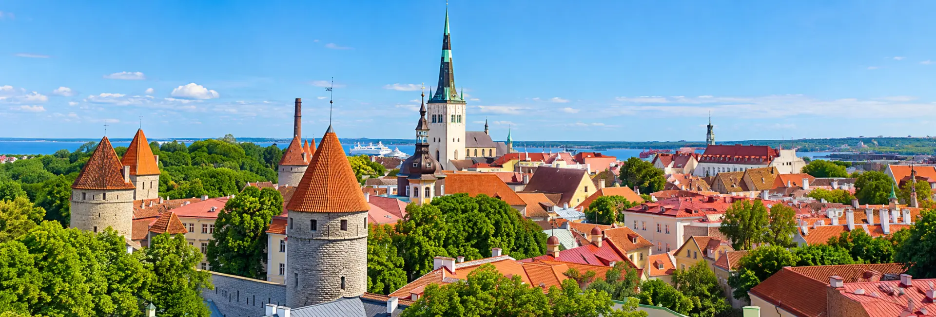 Panoramic view of Tallinn Old Town, Estonia, featuring medieval towers, red rooftops and historic architecture.