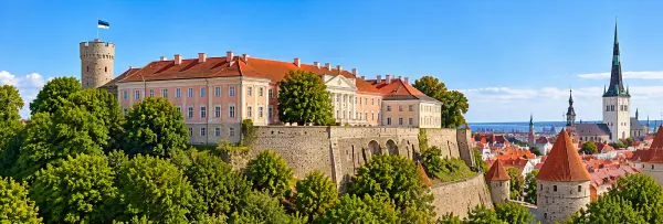 Panoramic view of Toompea Castle in Tallinn, Estonia, featuring its pink facade, historic towers and stone walls.