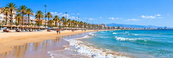 Malvarrosa Beach in Valencia, Spain, featuring golden sand, turquoise Mediterranean waters, and palm-lined promenades.