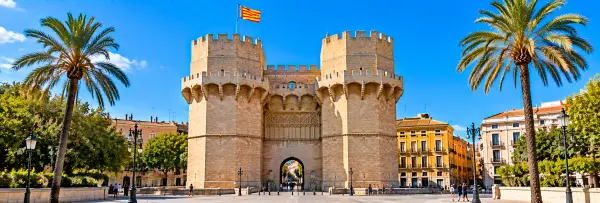 Torres de Serranos in Valencia, Spain, featuring historic Gothic towers and a grand stone gateway.