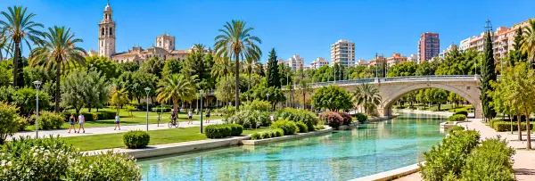 Turia Gardens in Valencia, Spain, featuring lush greenery, scenic waterways, and a stone bridge.