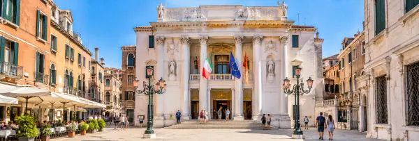 Teatro La Fenice in Venice, Italy, with its ornate neoclassical façade and lively surrounding square.