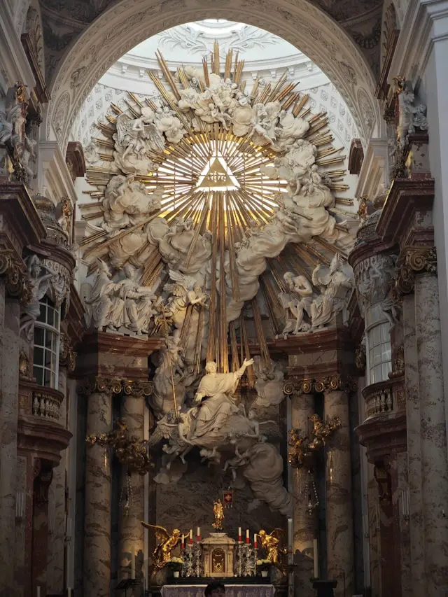 Interior of Karlskirche in Vienna featuring an ornate Baroque altar and radiant golden sculpture