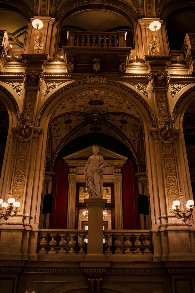 Ornate interior of the Vienna State Opera with a classical statue and gilded decorations