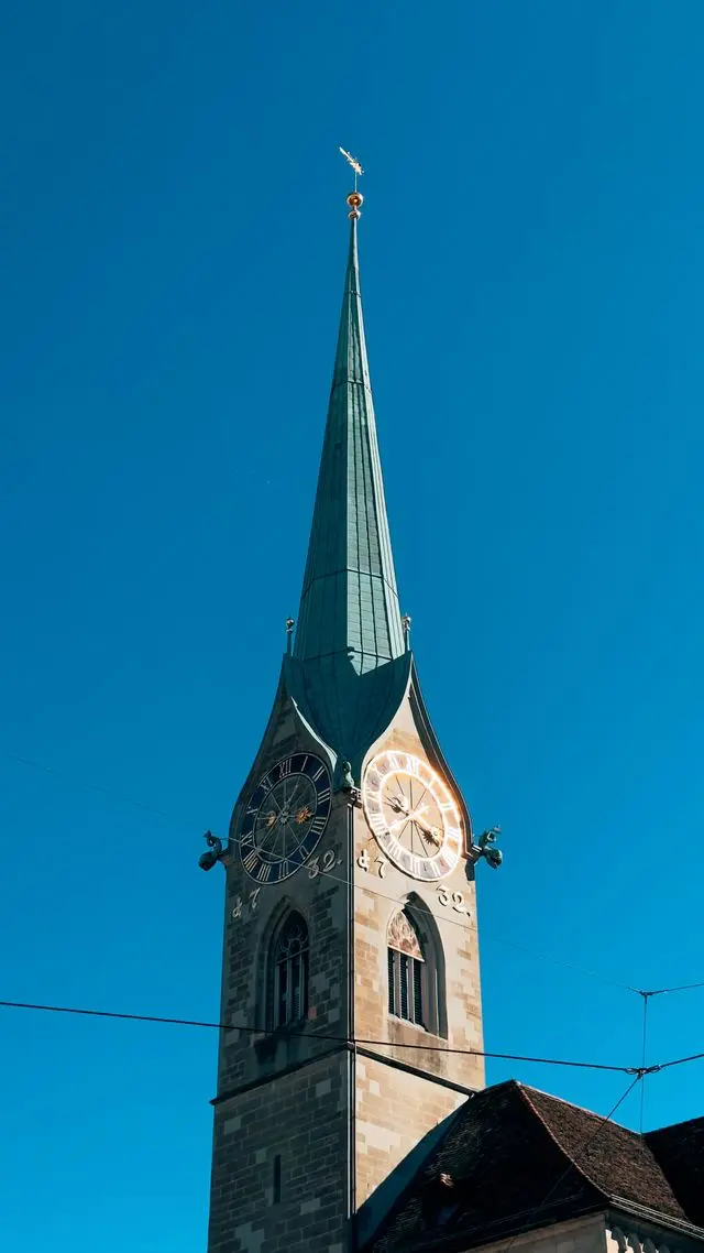 Close-up view of the Fraumünster tower and green spire against a blue sky