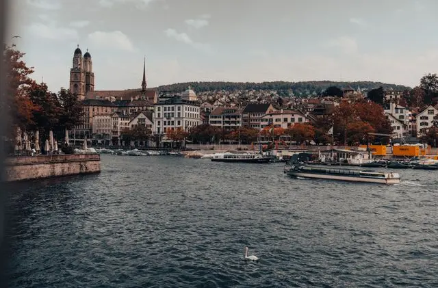 Lake Zurich waterfront with boats, historic buildings and Zurich city skyline