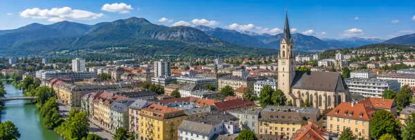 Villach, Austria panoramic cityscape with church, river, and Alps