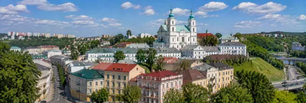 Panoramic view of Grodno, Belarus, with historic buildings, cathedral and lush green hills