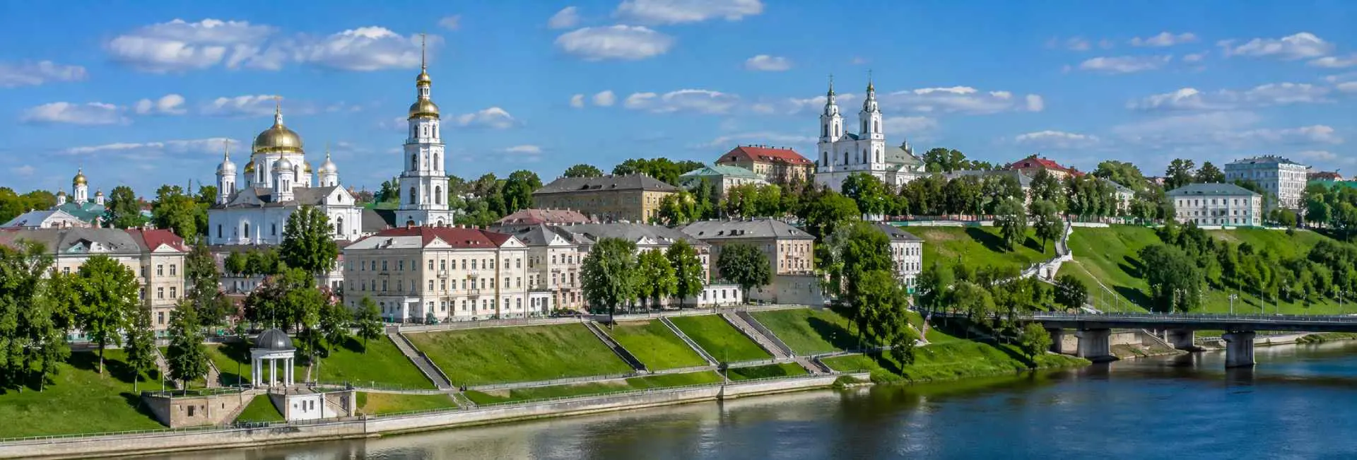 Panoramic view of Vitebsk, Belarus, with historic churches, green embankments and the Western Dvina River