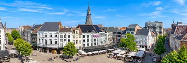 Hasselt, Belgium city square with historic buildings, cafés and the iconic church clock tower