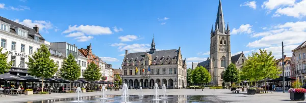 Roeselare market square with historic city hall, church tower, cafés and fountain in Belgium