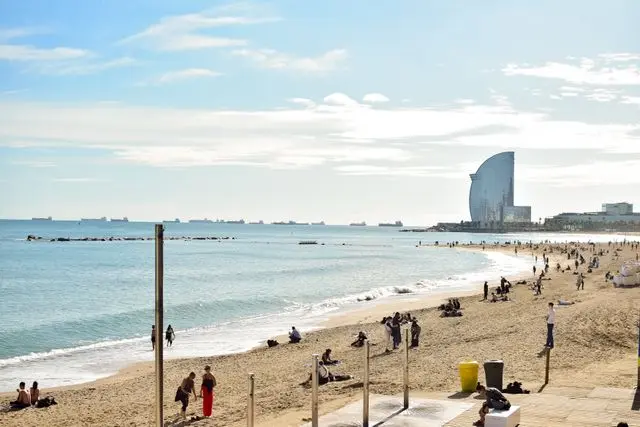 Barceloneta Beach with sandy shore and W Barcelona Hotel in the distance