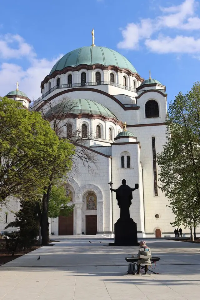 Church of Saint Sava in Belgrade, Serbia, featuring massive green domes, white stone walls, and a grand entrance.