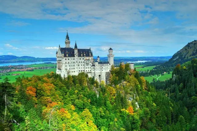 Neuschwanstein Castle surrounded by autumn forest and Bavarian countryside
