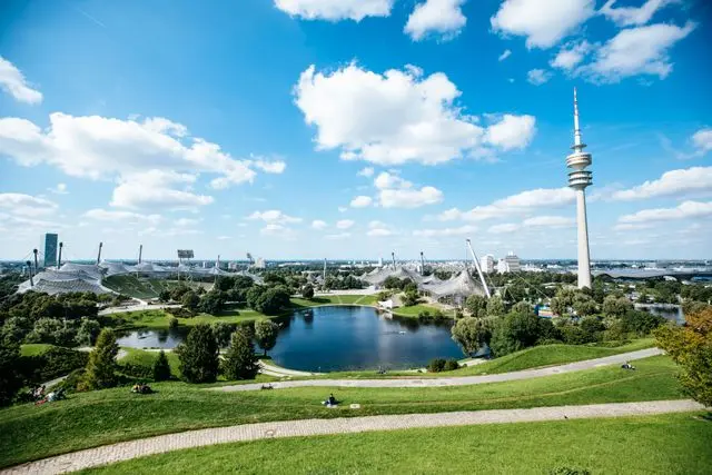 Olympiapark Munich with lake, green lawns, Olympic Stadium and Olympic Tower