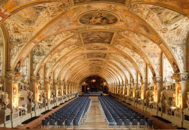 Antiquarium hall at Munich Residenz with ornate frescoes, sculptures and rows of chairs