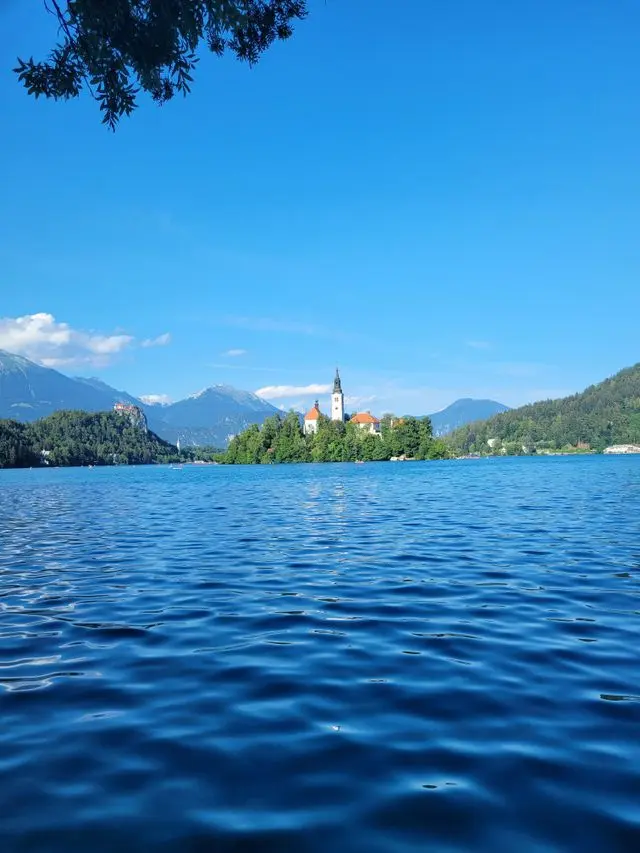 Lake Bled in Slovenia with Bled Island church, surrounded by the Julian Alps and blue waters.