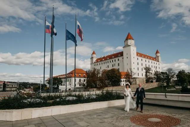 Bratislava Castle in Slovakia, featuring white walls, red roofs, and four corner towers overlooking the city.