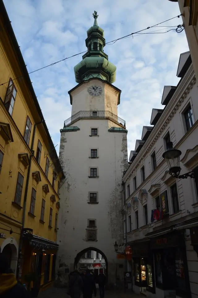 Michael’s Gate in Bratislava Old Town, featuring a historic white tower, clock, and green copper roof.
