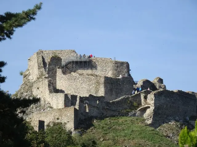Medieval ruins of Devín Castle in Bratislava, Slovakia, standing on a rocky hill surrounded by greenery.