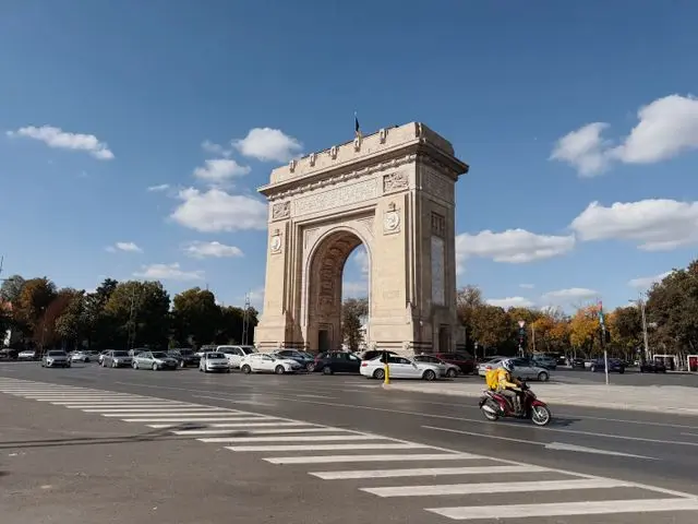 Arcul de Triumf in Bucharest, Romania, featuring a monumental stone arch surrounded by roads and greenery.