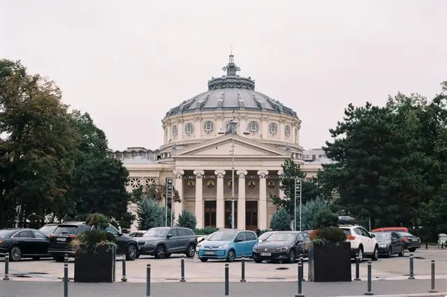 Romanian Athenaeum in Bucharest, featuring a magnificent domed roof, classical columns, and neoclassical architecture.