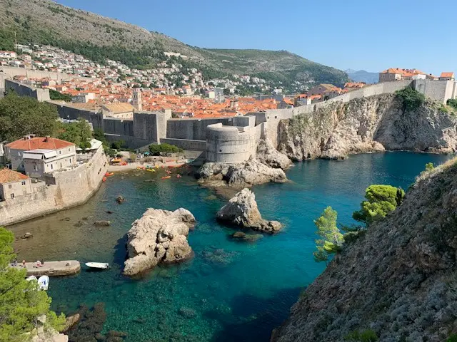 Dubrovnik City Walls in Croatia, featuring medieval stone fortifications, rocky cliffs, and turquoise Adriatic waters.