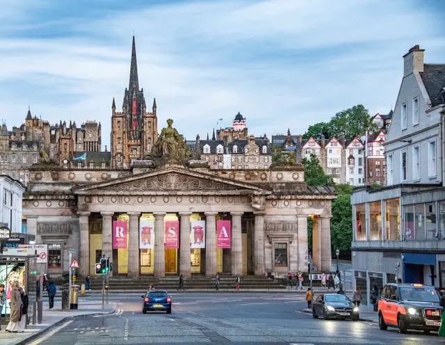 Historic Edinburgh building with classical columns and church spire in the city centre