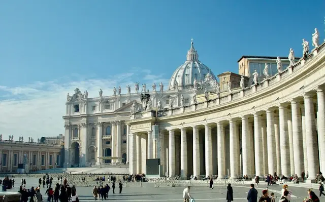 atican Museums complex in Vatican City with its grand Renaissance architecture and visitors in the courtyard.
