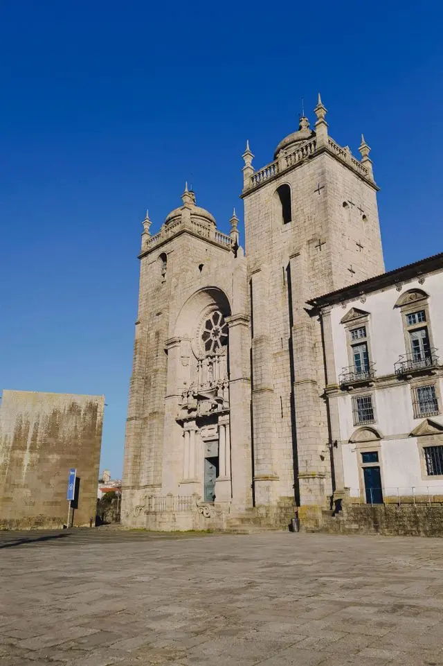 Historic stone church with ornate towers and arched windows in Porto, Portugal.